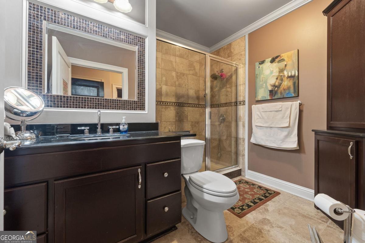 1151 Spring Station Road Greensboro, GA 30642 - Photo 42 of 60 a bathroom with a sink a toilet and shower