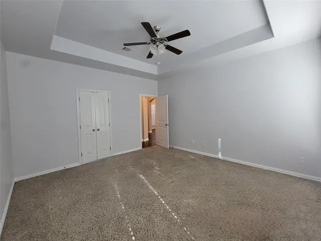 an empty room with a ceiling fan and window