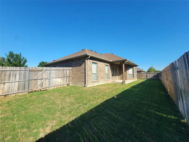 a house with green field in front of it