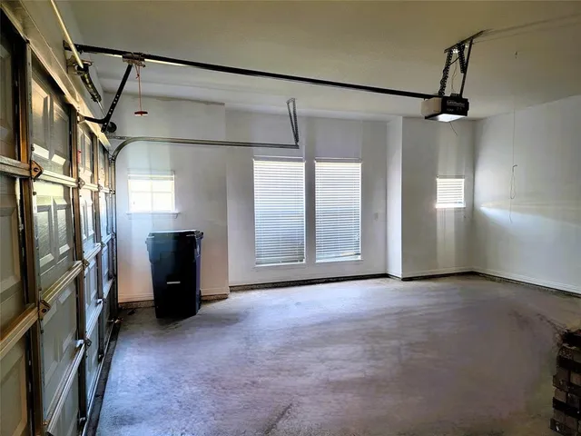 a view of empty room with windows and refrigerator