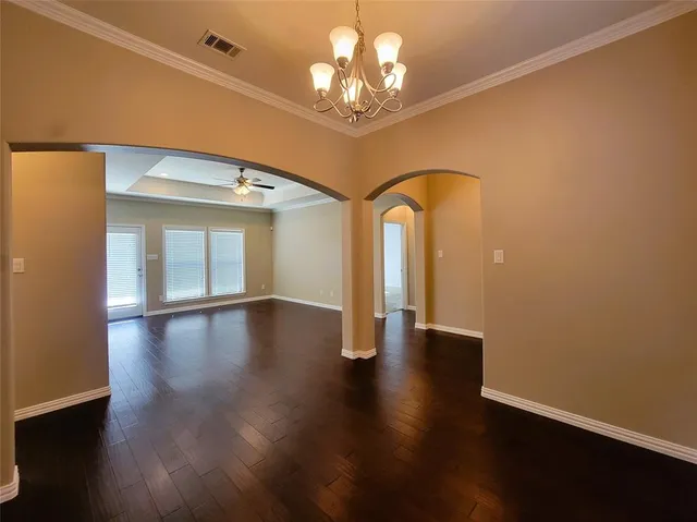 a view of a room with wooden floor chandelier and a window