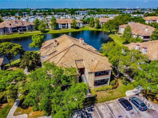an aerial view of a house with a garden and lake view