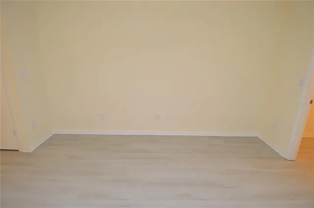a view of a lake with a bench and trees in the background