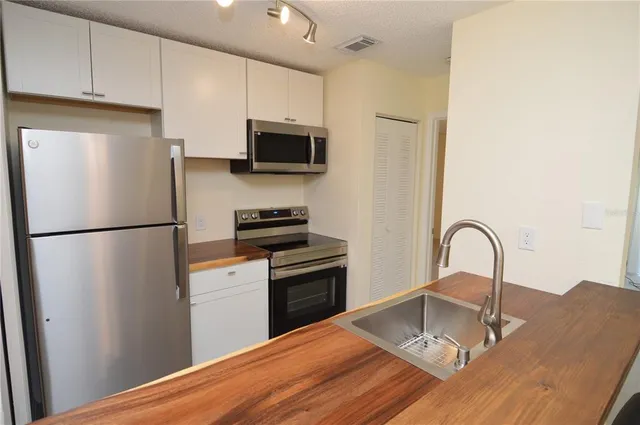 a kitchen with stainless steel appliances a refrigerator and a stove top oven