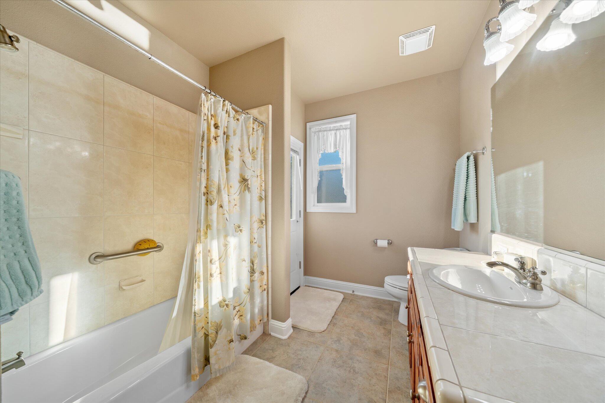 7870 Castle View Lane Redding, CA 96001 - Photo 34 of 65 a bathroom with a granite countertop sink a toilet and shower