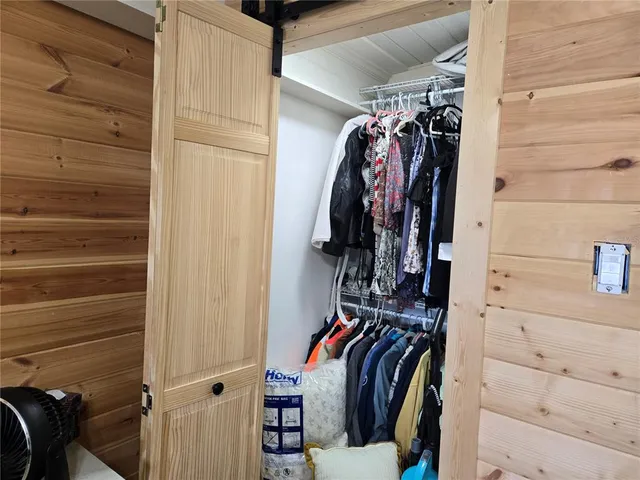 a view of walk in closet with clothes