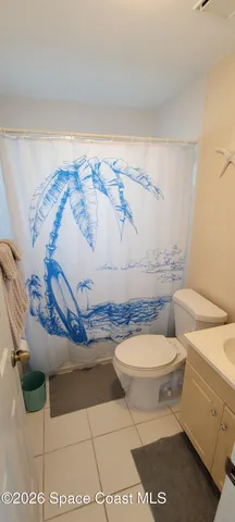 a bathroom with a toilet and a shower curtain