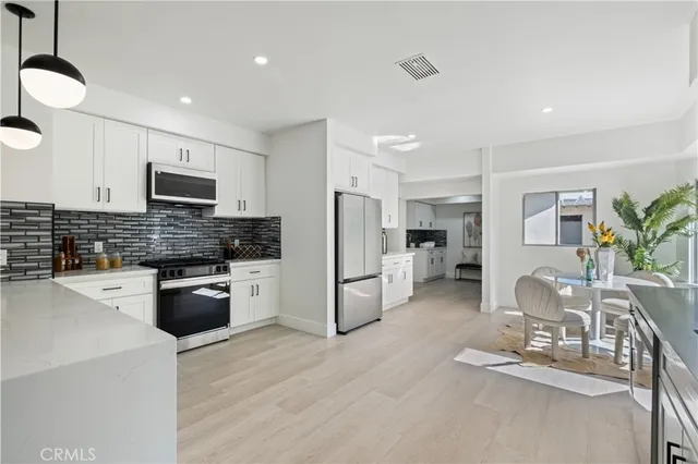 a very nice looking dining room with kitchen island furniture a large window and kitchen view