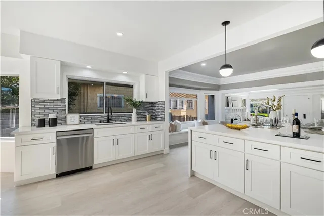 a kitchen with granite countertop a stove top oven a sink dishwasher a refrigerator and a dining table with wooden floor