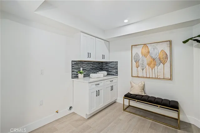 a kitchen with stainless steel appliances a white refrigerator a kitchen island a stove a dining table and chairs