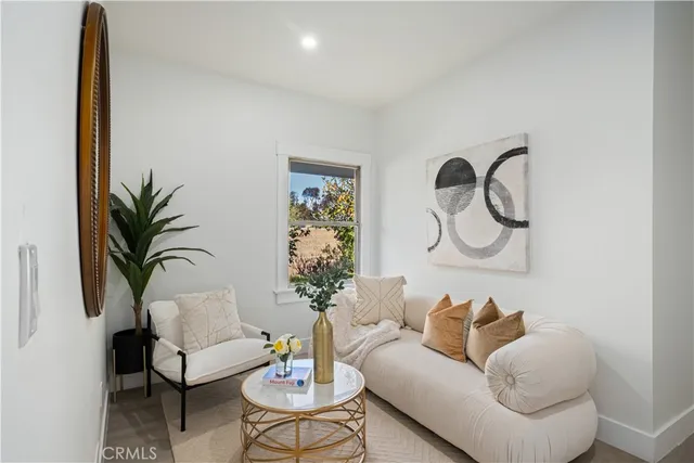 a living room with furniture a window and a potted plant