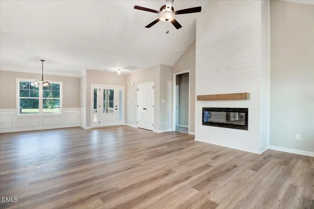 a view of an empty room with a window and fireplace