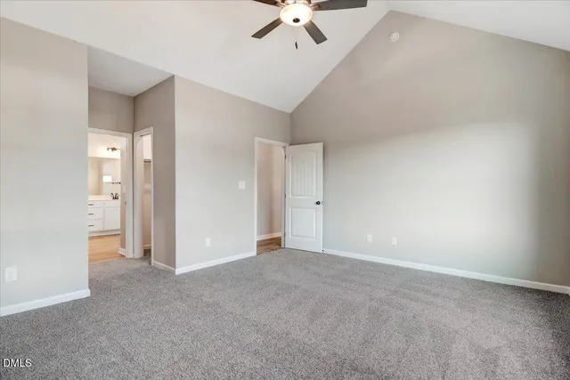 an empty room with a ceiling fan and carpet