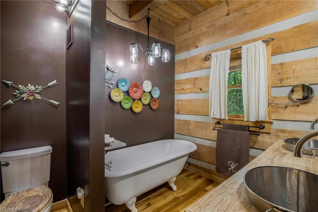 154 Rierson Road Madison, NC 27025 - Photo 16 of 30 Primary bathroom with bear claw tub, unique mason jar chandelier and separate walk in shower