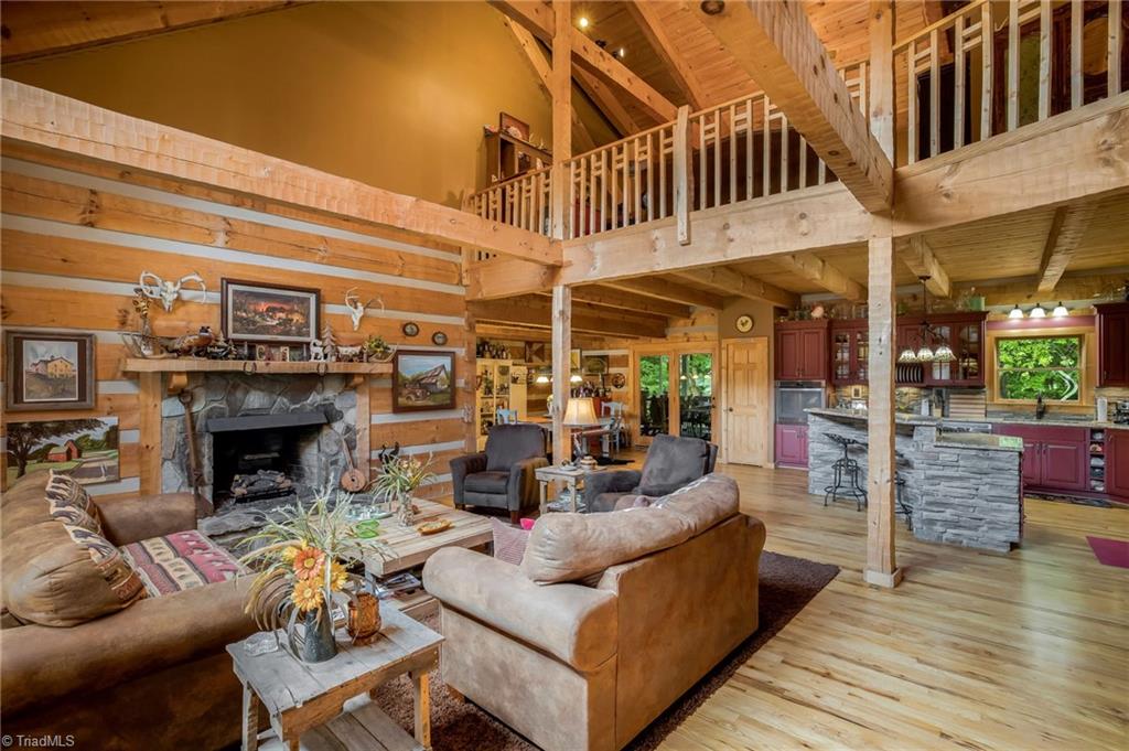 154 Rierson Road Madison, NC 27025 - Photo 7 of 30 Great Room with vaulted ceilings and stone fireplace. Open floor plan with kitchen and dining room