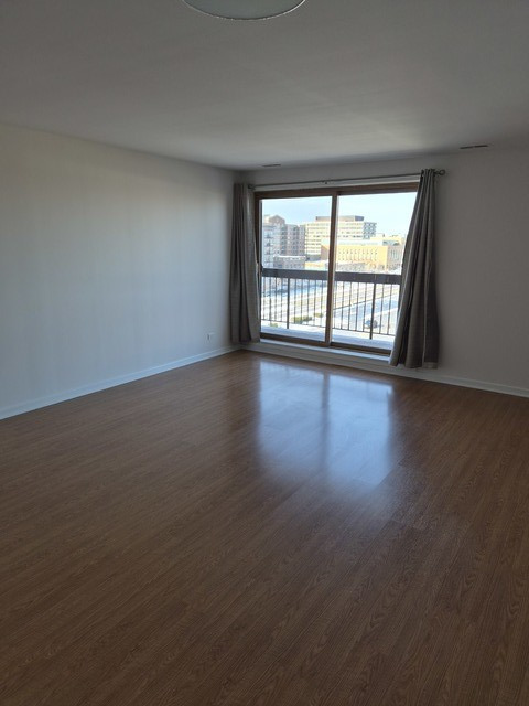 711 South River Road, Unit 704 Des Plaines, IL 60016 - Photo 5 of 15 a view of an empty room with wooden floor and a window