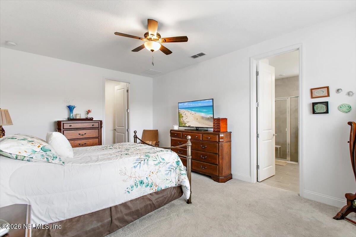 100 Simonson Run St. Augustine, FL 32092 - Photo 16 of 30 a bedroom with a bed and a chandelier