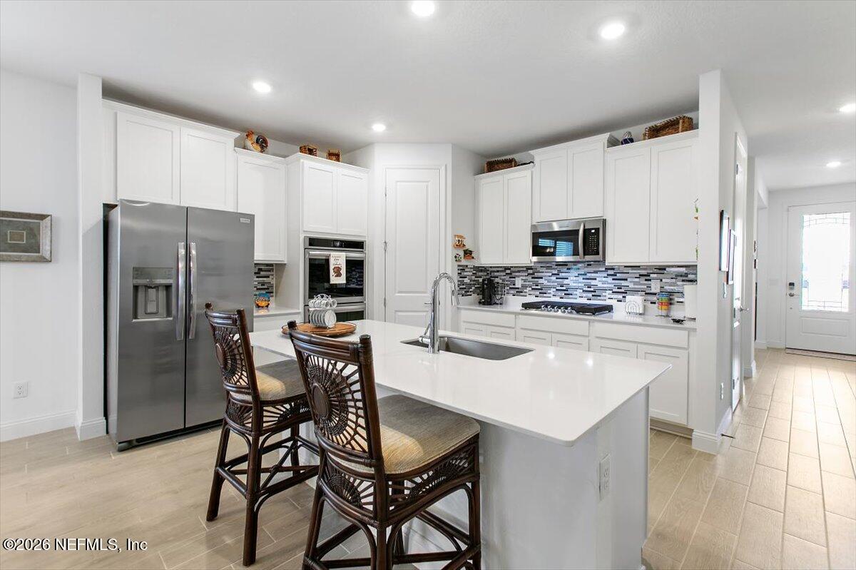 100 Simonson Run St. Augustine, FL 32092 - Photo 8 of 30 a kitchen with stainless steel appliances a refrigerator stove microwave and cabinets