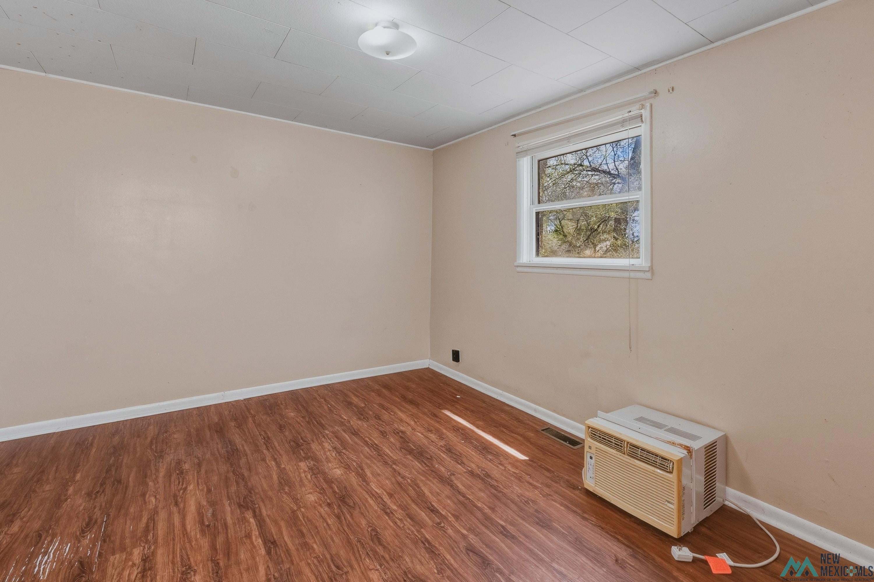 533 South 2nd Street Raton, NM 87740 - Photo 31 of 43 Room featuring wood-finish flooring, neutral wall paint, and a white trim baseboard