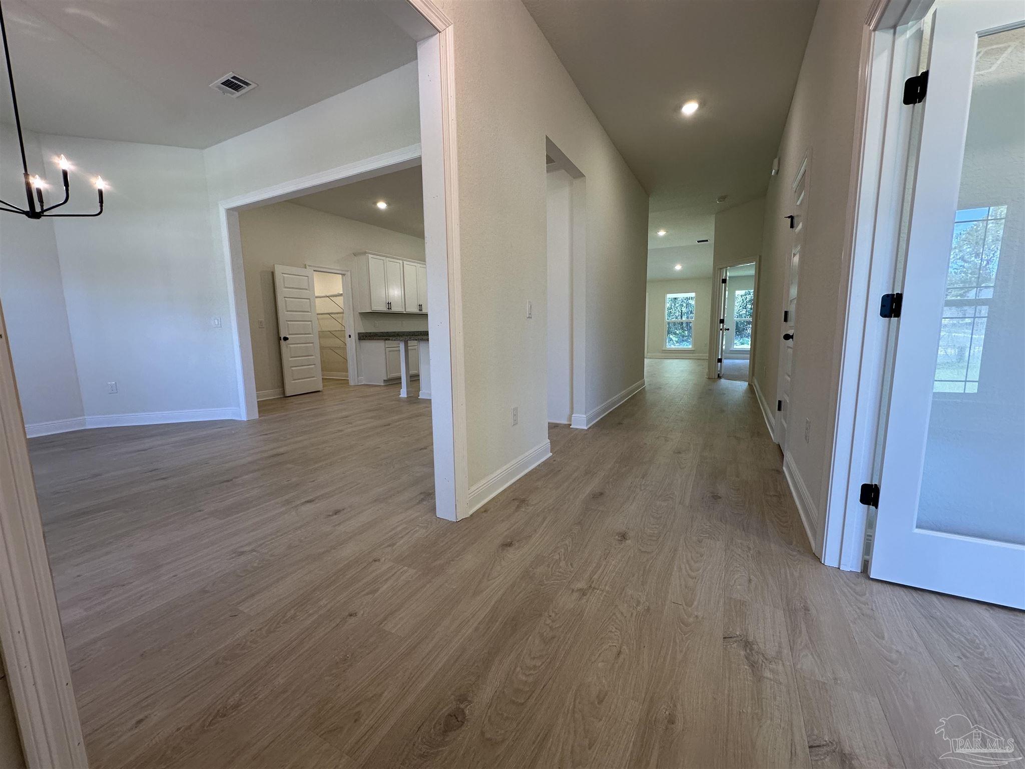 5223 Wahoo Road Milton, FL 32583 - Photo 14 of 26 wooden floor in an empty room with a bathroom