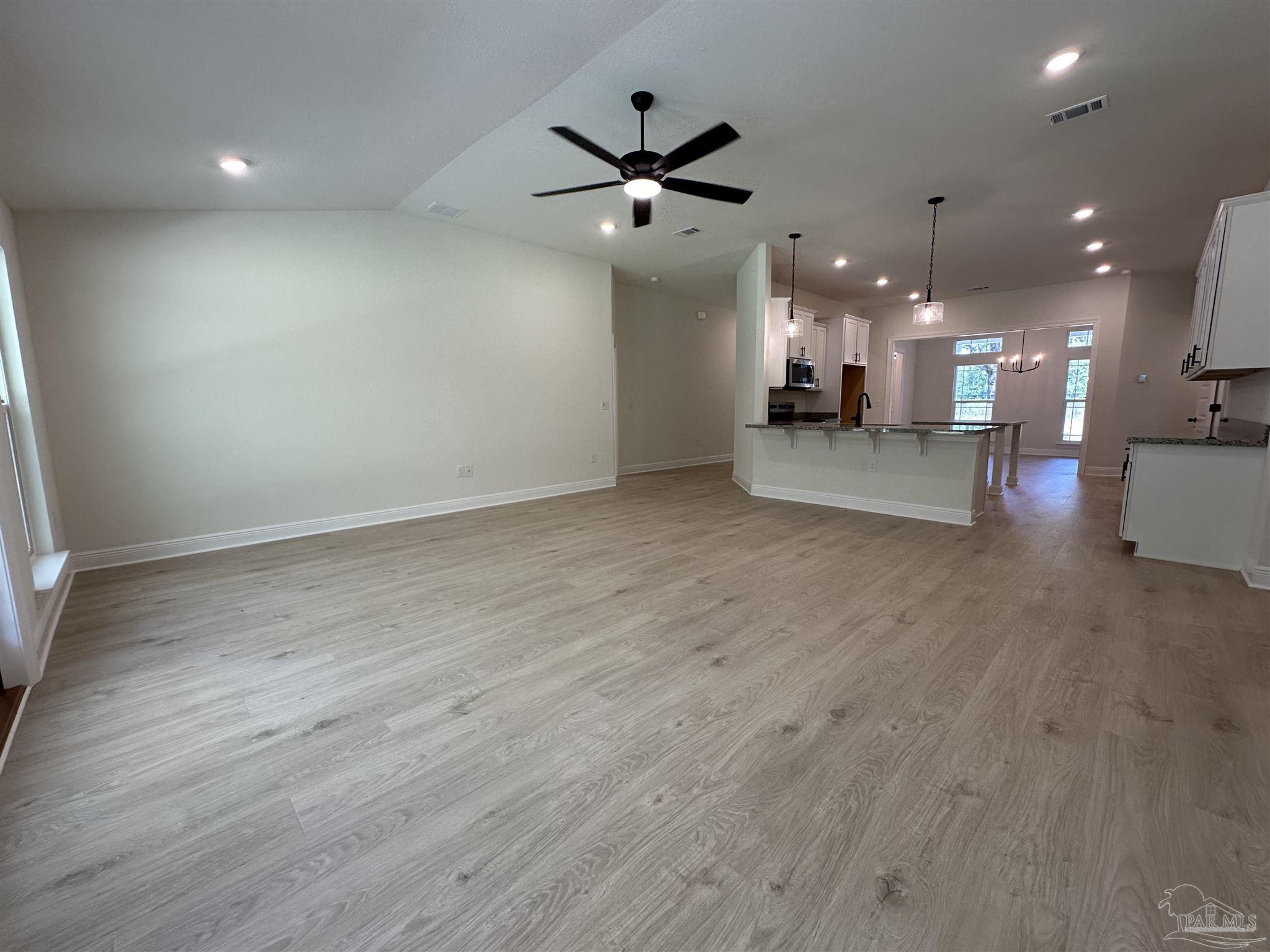 5223 Wahoo Road Milton, FL 32583 - Photo 16 of 26 an empty room with wooden floor and a ceiling fan