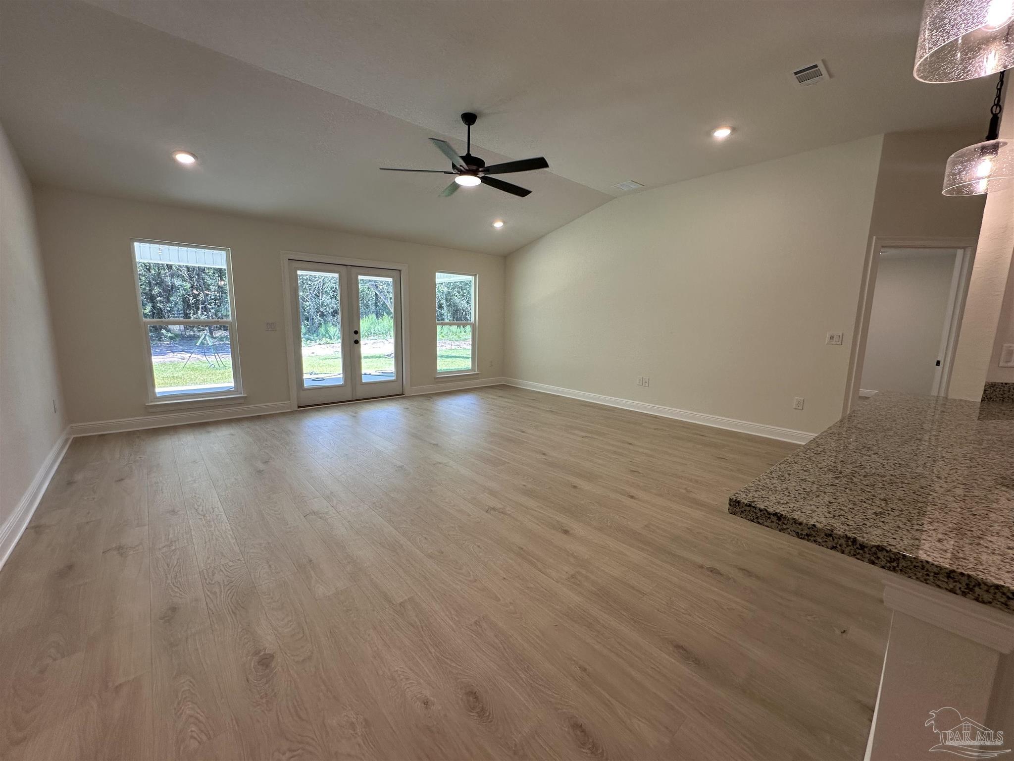 5223 Wahoo Road Milton, FL 32583 - Photo 19 of 26 an empty room with wooden floor fan and windows