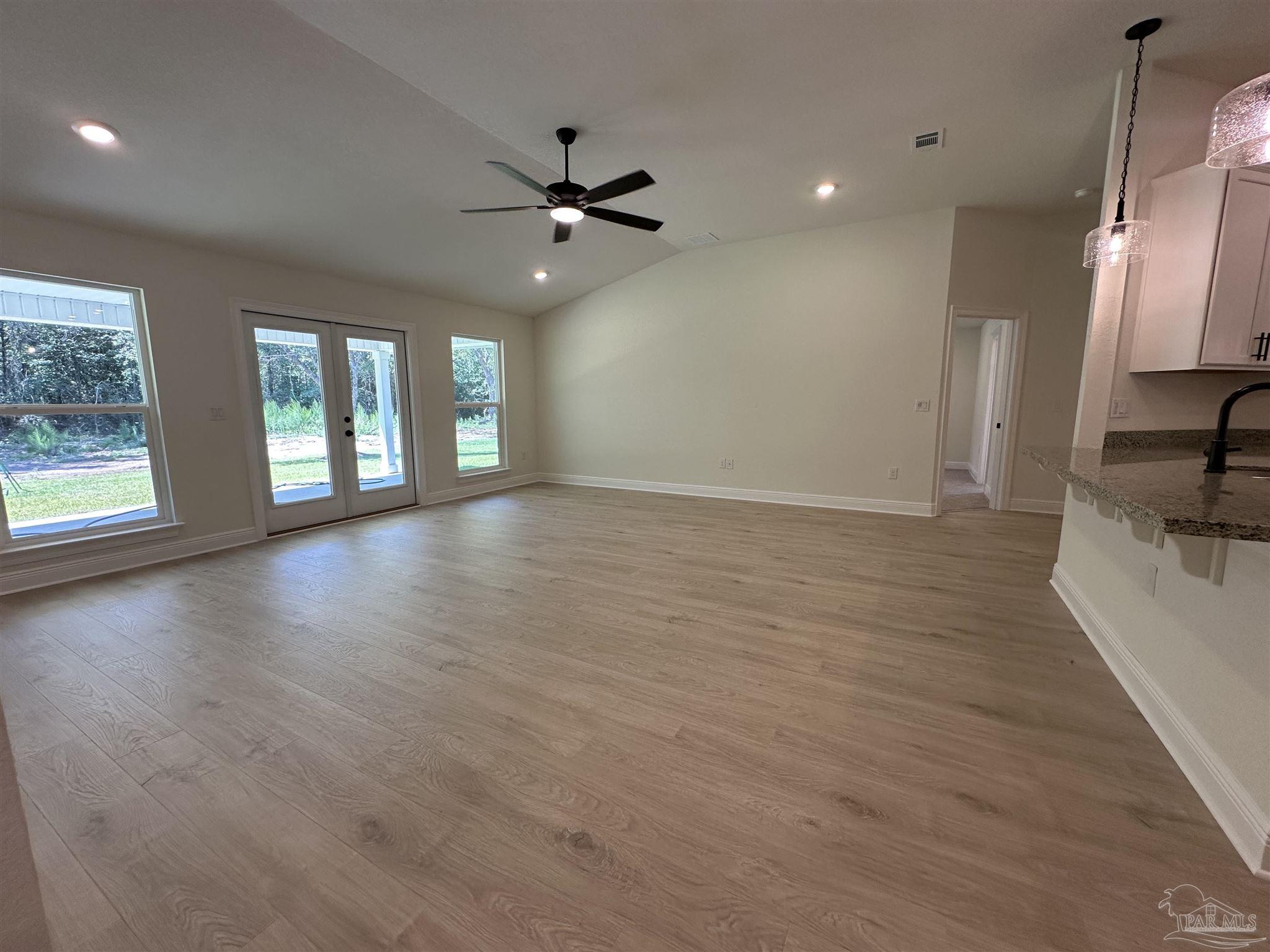 5223 Wahoo Road Milton, FL 32583 - Photo 20 of 26 an empty room with wooden floor fan and windows