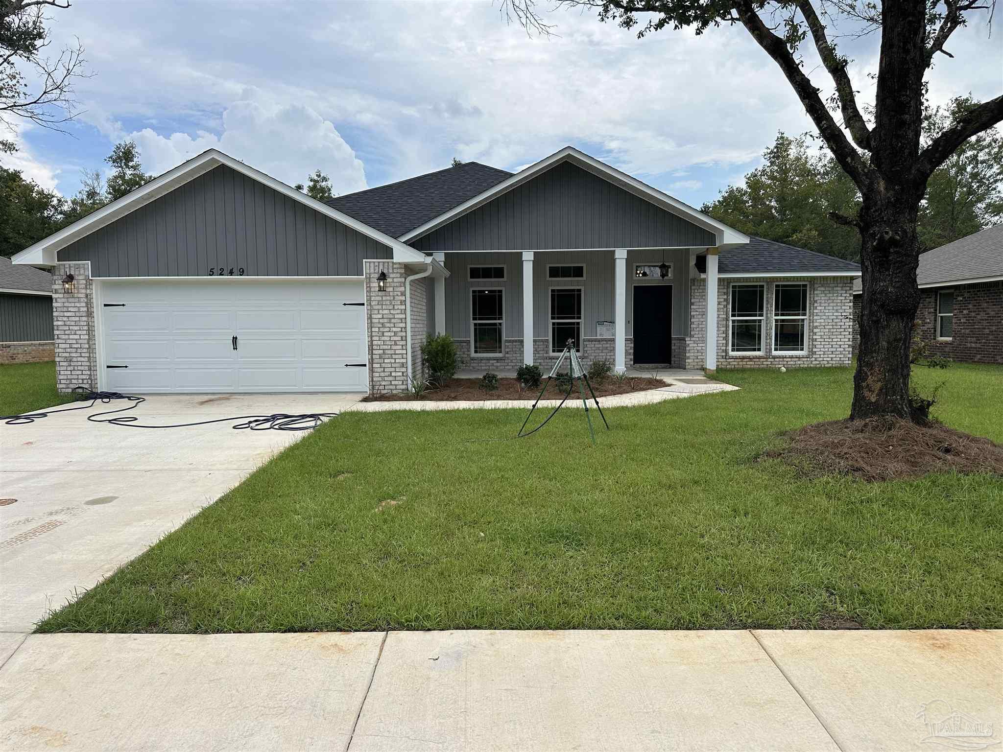 5223 Wahoo Road Milton, FL 32583 - Photo 2 of 26 a front view of house with a garden and patio