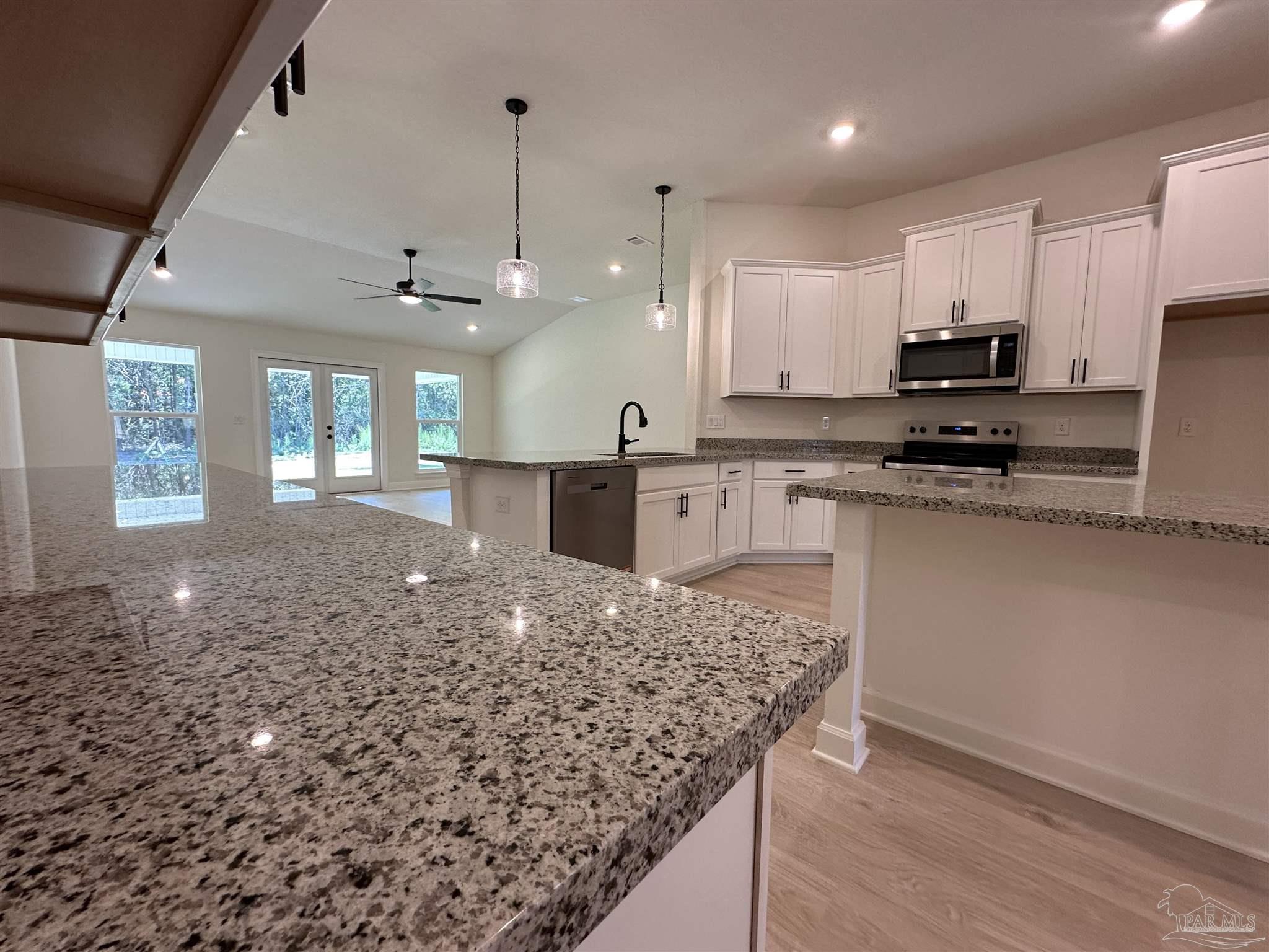 5223 Wahoo Road Milton, FL 32583 - Photo 4 of 26 a kitchen with stainless steel appliances granite countertop a sink stove and a granite counter top