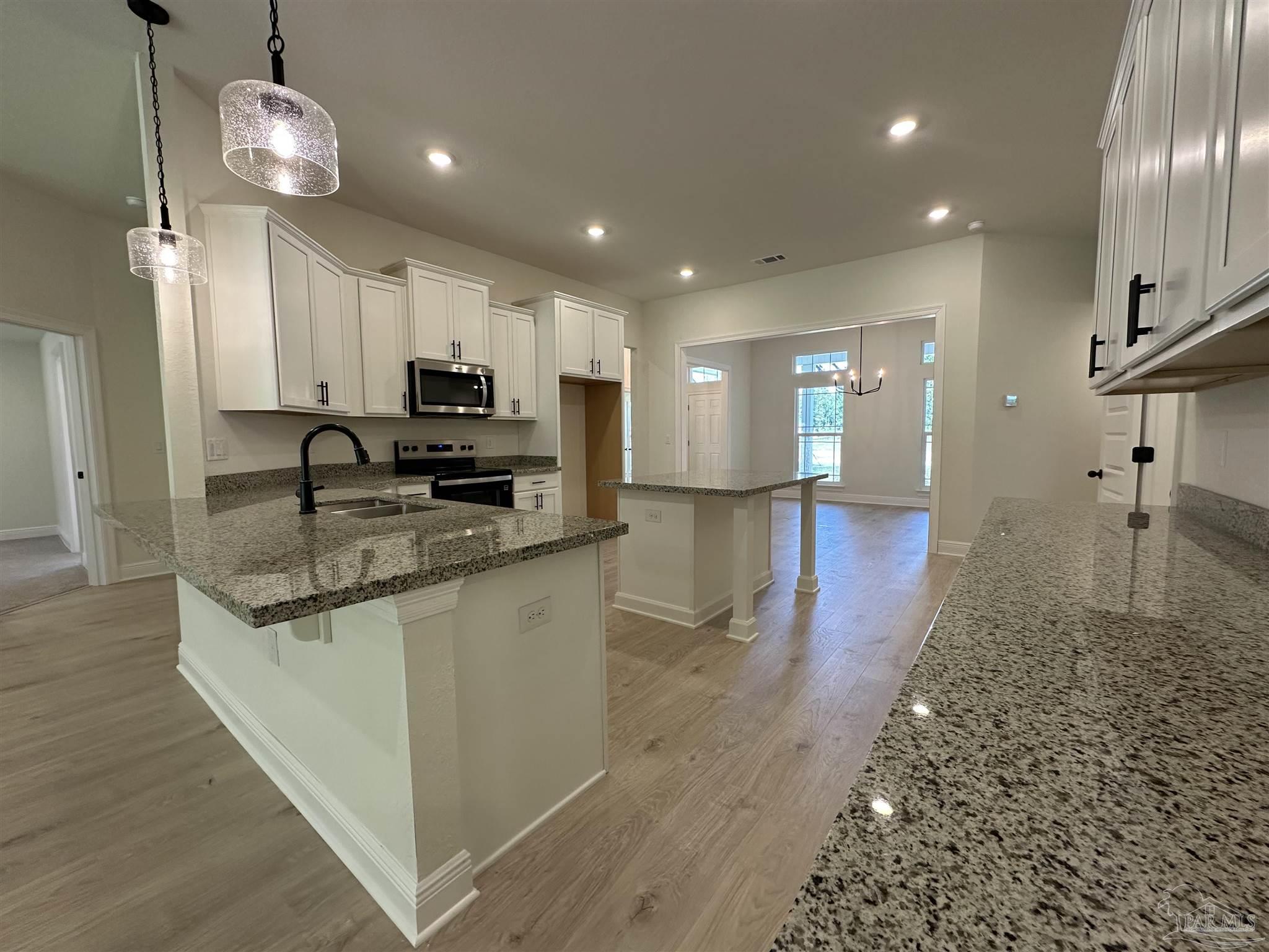 5223 Wahoo Road Milton, FL 32583 - Photo 8 of 26 a view of a kitchen with granite countertop stainless steel appliances sink and wooden floor
