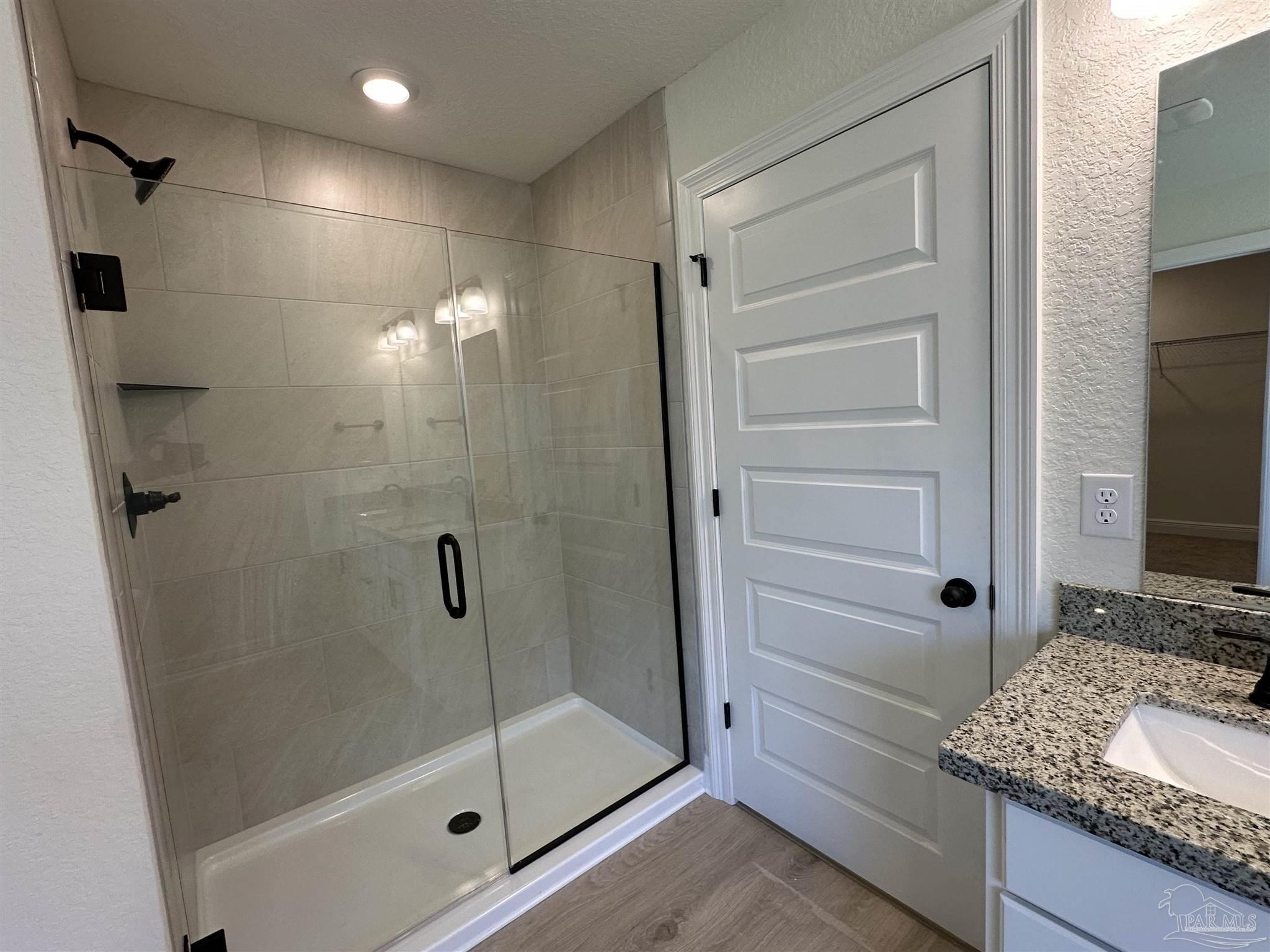 5223 Wahoo Road Milton, FL 32583 - Photo 9 of 26 a bathroom with a granite countertop sink a mirror and shower