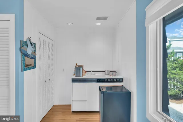 a kitchen with stainless steel appliances a dining table chairs stove and white cabinets