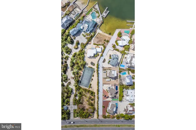 a bedroom with a bed a table and large windows