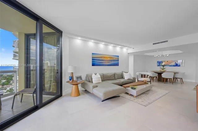 a living room with furniture and a floor to ceiling window
