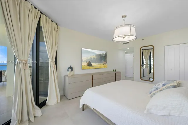 a bedroom with a large bed and a chandelier