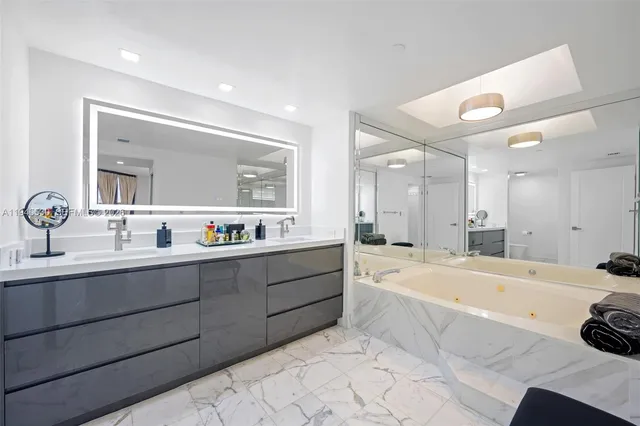 a large spacious bathroom with a tub sink and mirror