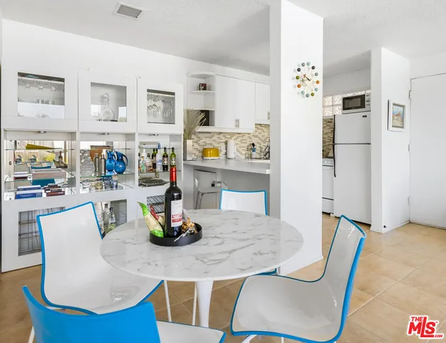 a kitchen with stainless steel appliances granite countertop a table and chairs