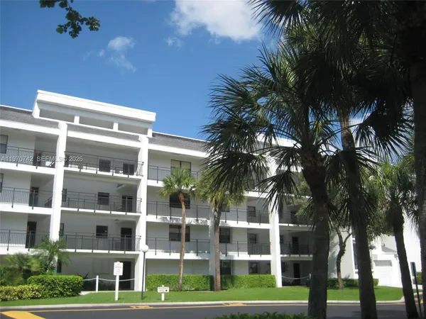 a front view of a building with palm trees