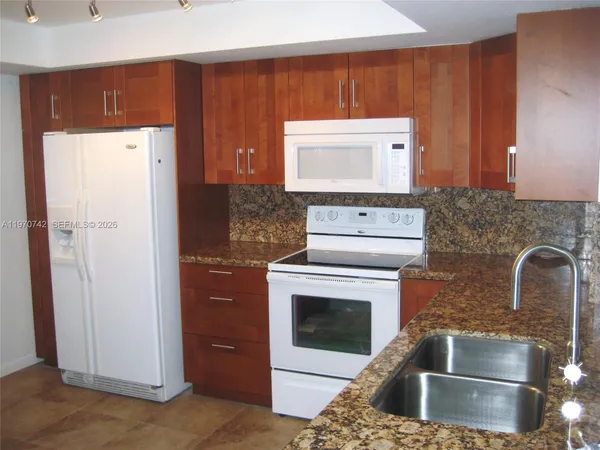 a kitchen with a refrigerator sink and cabinets