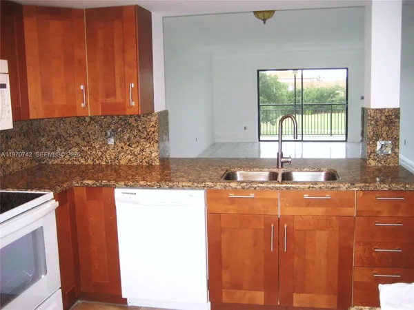 a kitchen with granite countertop cabinets washer and dryer