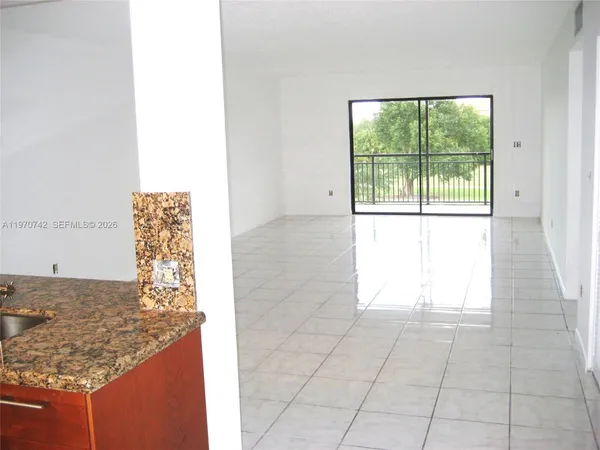 a view of kitchen with granite countertop cabinets and window