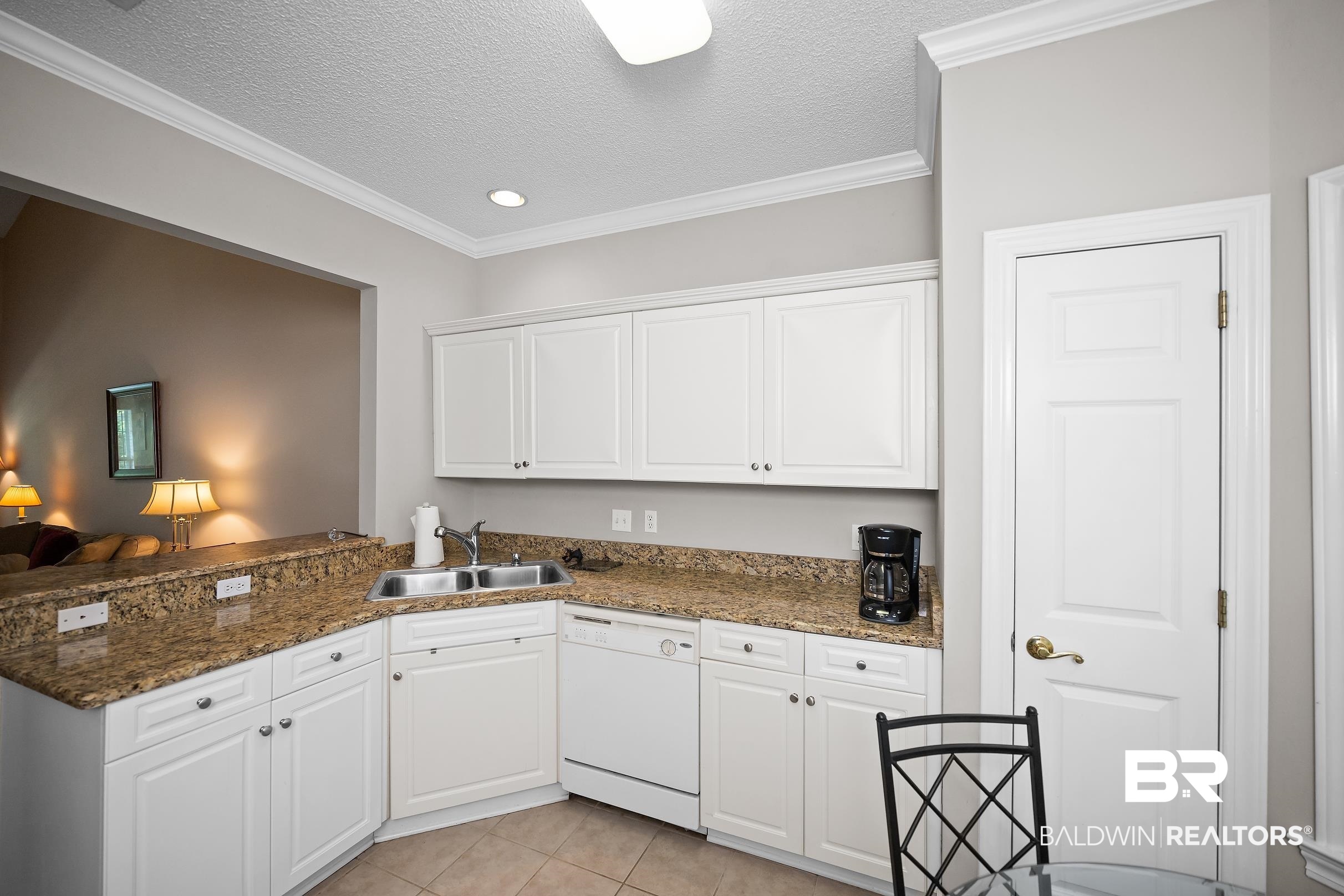 430 West Fort Morgan Road, Unit 704 Gulf Shores, AL 36542 - Photo 10 of 35 Kitchen featuring white cabinetry, granite-finish countertops, and an undermount double-basin sink