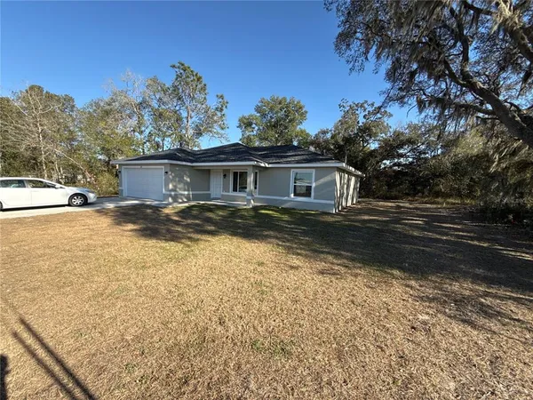 a view of a house with pool and sitting area