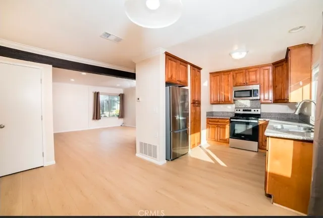 a kitchen with granite countertop stainless steel appliances and refrigerator