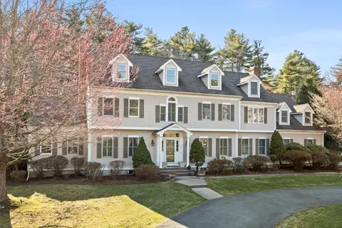 a front view of a house with a garden and plants