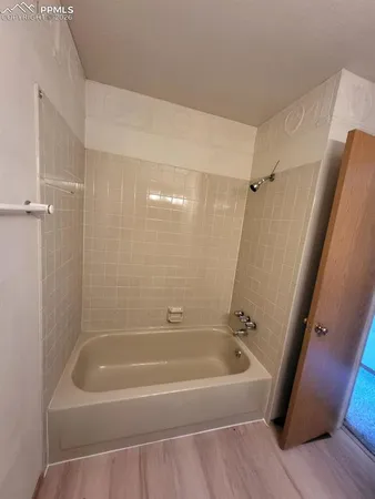 a white bath tub sitting next to a shower
