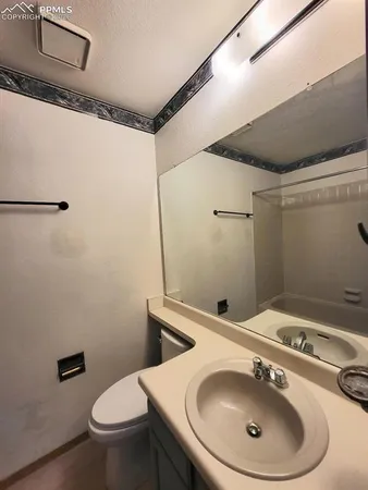 a bathroom with a sink a toilet and a mirror