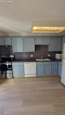 a view of a kitchen with stainless steel appliances a refrigerator and a stove