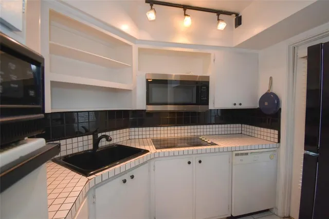 a kitchen with a sink a microwave and cabinets