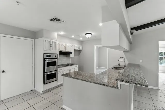 a kitchen with stainless steel appliances granite countertop a sink stove and cabinets